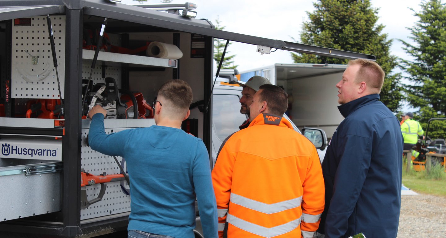 Vier Männer schauen sich den Innenausbau in einem Technikerauto an.